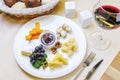 Appetizer `Cheese plate` with nuts and wineglass on a dark background Royalty Free Stock Photo