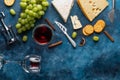 Appetizer with cheeses and red wine, snacks and grapes for a romantic dinner.Top view on a blue texture Royalty Free Stock Photo