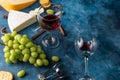 Appetizer with cheeses and red wine, snacks and grapes for a romantic dinner.Top view on a blue texture Royalty Free Stock Photo