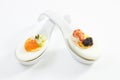 Appetizer with egg and caviar on spoon, elevated view