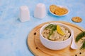 Appetizer, fish pate from mackerel, boiled eggs and onions in a white ceramic bowl on a blue concrete background. Served with Royalty Free Stock Photo