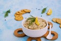 Appetizer, fish pate from mackerel, boiled eggs and onions in a white ceramic bowl on a blue concrete background. Served with Royalty Free Stock Photo