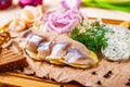 Appetizer. Herring, boiled potato, toasted bread, pickles, onion on wooden board