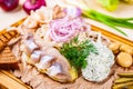 Appetizer. Herring, boiled potato, toasted bread, pickles, onion on wooden board