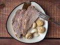 Appetizer with homemade pork ham and pickled mushrooms and garlic on a ceramic plate standing on a wooden tray close-up Royalty Free Stock Photo