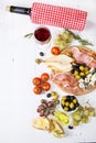 Appetizer, italian antipasto, ham, olives, cheese, bread, grapes, pear and wine on white wood background Royalty Free Stock Photo