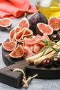 Appetizer of jamon, salami, bread sticks, Kalamata olives and figs