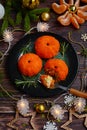 An appetizer for the New Year`s table made in the form of tangerines on a dark plate against a background of decorations and Royalty Free Stock Photo