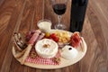 Appetizer plate with French and Italian cheeses, ham and wine