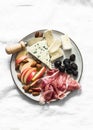 Appetizer plate - prosciutto, gorgonzola, brie cheese, olives, apples, nuts almonds on a light background, top view Royalty Free Stock Photo