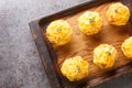 Appetizer potato muffins with bacon and cheese on wooden board closeup. Horizontal top view