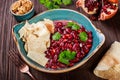 Appetizer with red bean, walnut, butter, coriander, parsley, chips on plate on wooden background. Healthy food