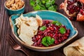 Appetizer with red bean, walnut, butter, coriander, parsley, chips on plate on wooden background. Healthy food.