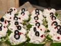 Appetizer with roe salad with black olives on cucumber slices, wooden background