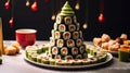 appetizer in shape of Christmas tree from rolls, sushi, red fish, traditional Japanese cuisine on festive New Year\'s table.