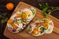 Appetizer toasts with pieces of squid, yellow tomatoes, sliced eggs and red onion, shrimp paste