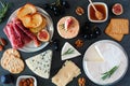 Appetizers of assorted cheeses and meats, above view table scene on a dark background