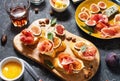 Appetizers board with traditional spanish tapas set. Italian antipasti bruschetta with prosciutto, cream cheese and fig.