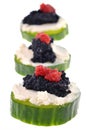 Appetizers with cucumber slices, cream cheese and black and red lump eggs close-up on white background