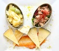 Appetizers in sardine cans and cheese wedges on carrot sauce