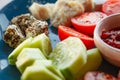 Appetizers, snacks, cheeses, sliced cucumbers and tomatoes, hot sauce, on plate, selective focus