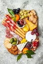 Appetizers table with antipasti snacks. Cheese and meat variety board over grey concrete background. Top view, flat lay. Royalty Free Stock Photo