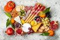 Appetizers table with antipasti snacks. Cheese and meat variety board over grey concrete background. Top view, flat lay. Royalty Free Stock Photo