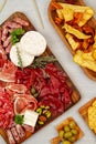 Appetizers table with differents antipasti, charcuterie, snacks and wine. Sausage, ham, tapas, olives, cheese and crackers for