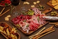 Appetizers table with differents antipasti, cheese, charcuterie, snacks and wine. Sausage, ham, tapas, olives, cheese and crackers Royalty Free Stock Photo