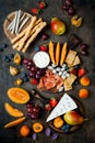 Appetizers table with italian antipasti snacks. Cheese and charcuterie variety board over rustic wooden background.