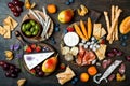 Appetizers table with italian antipasti snacks. Cheese and charcuterie variety board over rustic wooden background.