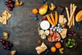 Appetizers table with italian antipasti snacks. Cheese and charcuterie variety board over rustic wooden background.