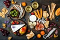 Appetizers table with italian antipasti snacks and wine in glasses. Cheese and charcuterie variety board over rustic wooden table Royalty Free Stock Photo