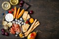 Appetizers table with italian antipasti snacks and wine in glasses. Cheese and charcuterie variety board over rustic wooden table Royalty Free Stock Photo