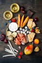 Appetizers table with italian antipasti snacks and wine in glasses. Cheese and charcuterie variety board over rustic wooden table