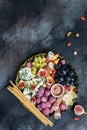 Appetizers table with italian antipasti snacks and wine in glasses. cheese, ham, nuts, fruit, bread sticks. Delicious balanced