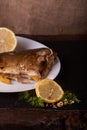 Appetizing baked fish, covered with juicy lemons, garlic and salt on side, above view Royalty Free Stock Photo