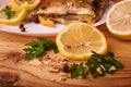 Appetizing baked fish, covered with juicy lemons, garlic and salt on side, above view Royalty Free Stock Photo