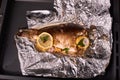 Appetizing baked fish, covered with juicy lemons, garlic and salt on side, top view Royalty Free Stock Photo