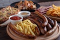 Appetizing beer snacks close up. Grilled sausages with french fr Royalty Free Stock Photo