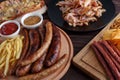 Appetizing beer snacks close up. Grilled sausages with french fr Royalty Free Stock Photo