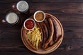 Appetizing beer snacks plate. Grilled sausages and french fries Royalty Free Stock Photo