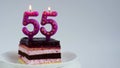 Appetizing birthday cake with burning candles for 55th anniversary