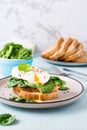 Appetizing bruschetta with poached egg and spinach on a plate. Keto diet. Vertical view