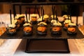 Appetizing canapes with smoked salmon on black tray. Catering service.