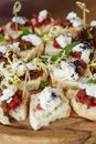 Appetizing canapes on a wooden board. Buffet snacks. Close-up. Vertical Royalty Free Stock Photo