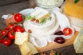 Cheese platter with fresh vegetables and nuts on wooden table Royalty Free Stock Photo