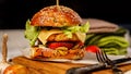 Appetizing chicken burger with cheddar cheese, fresh salad and vegetables on a cutting board. Fresh lettuce leaves and tomatoes Royalty Free Stock Photo