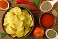 Appetizing composition: potato chips, tomato and chili peppers o