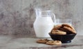 Sweet cookies with roasted peanuts on a beautiful plate and on the table. Jug of fresh milk and glass on grey background Royalty Free Stock Photo